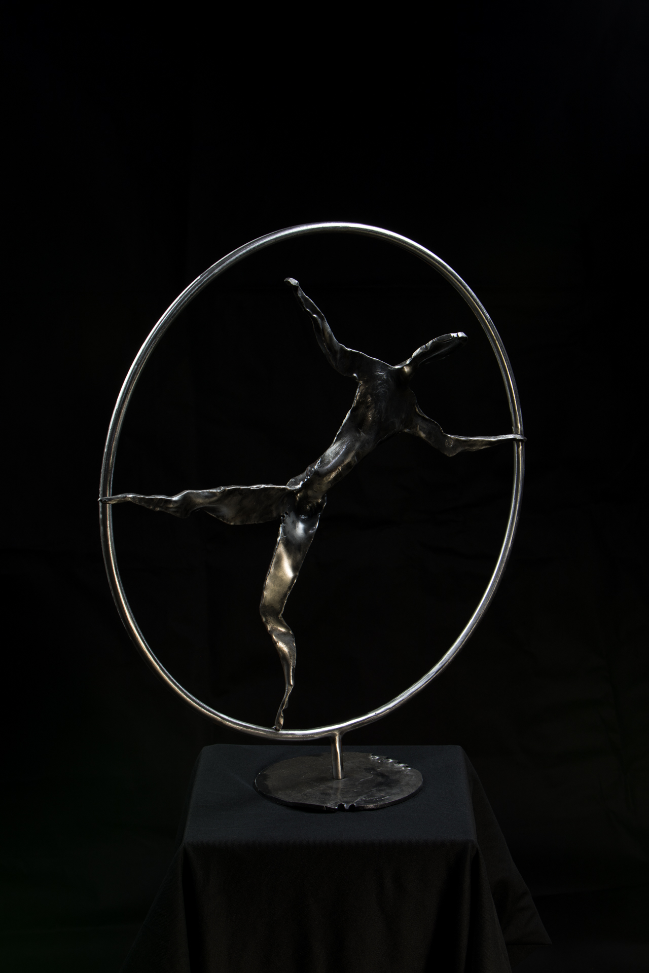 Elegant metal sculpture of a ballet dancer inside a circular frame