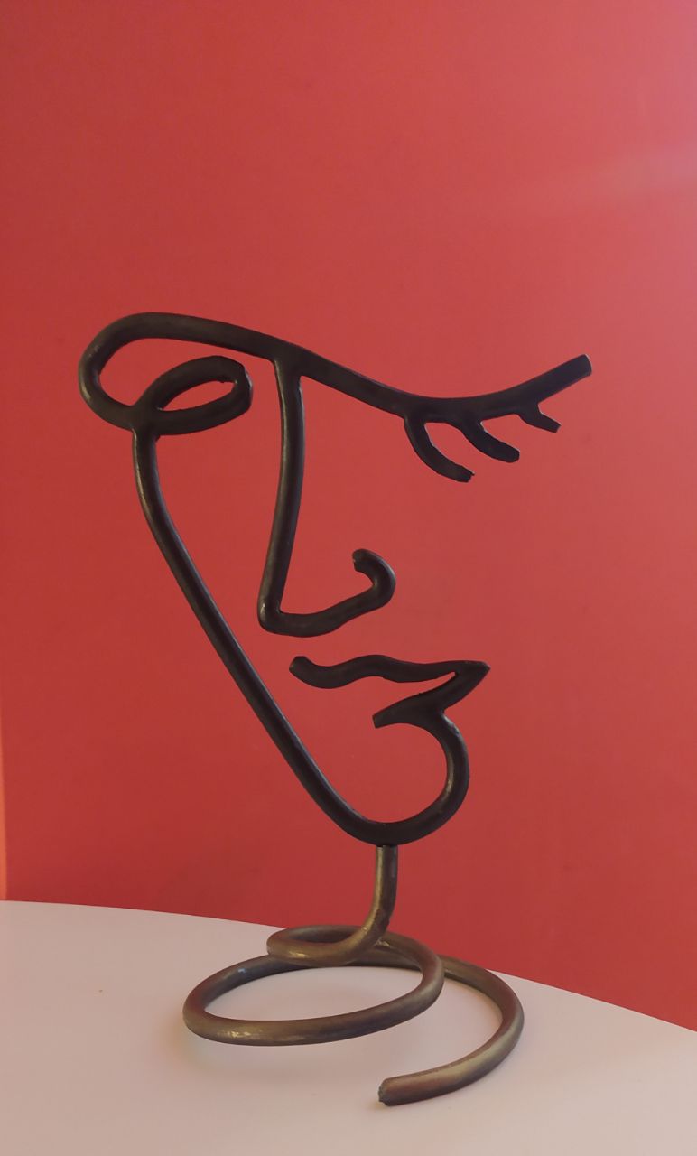 Minimalist abstract face sculpture in wrought iron