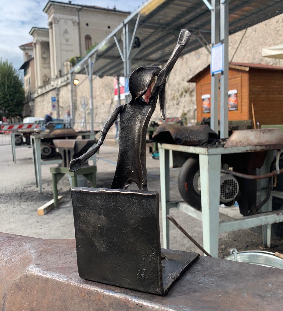 Handcrafted celebrative iron figure with raised arm