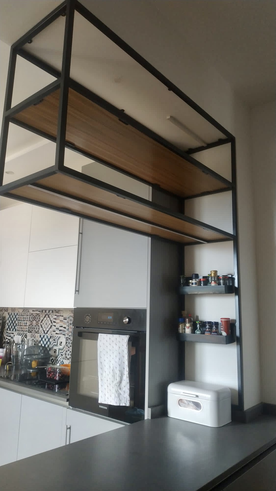 Suspended kitchen shelves with black metal frame and wooden boards, LED lighting