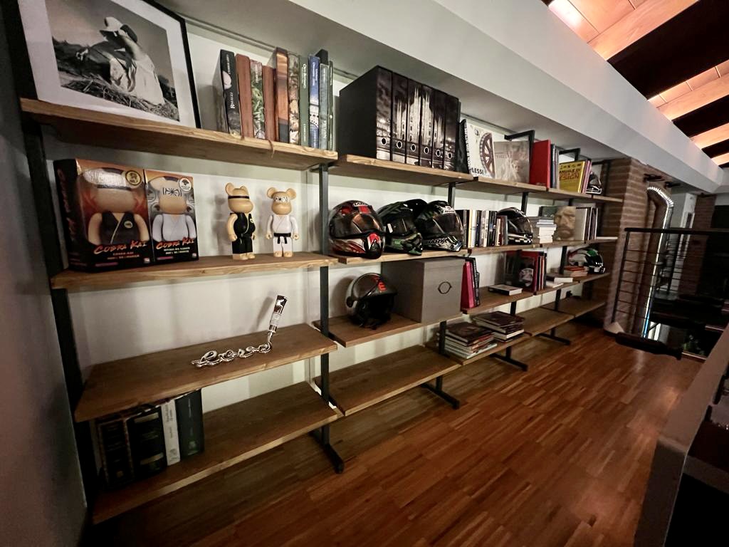 Custom floor-to-ceiling bookshelf with black metal frame displaying books and collectibles