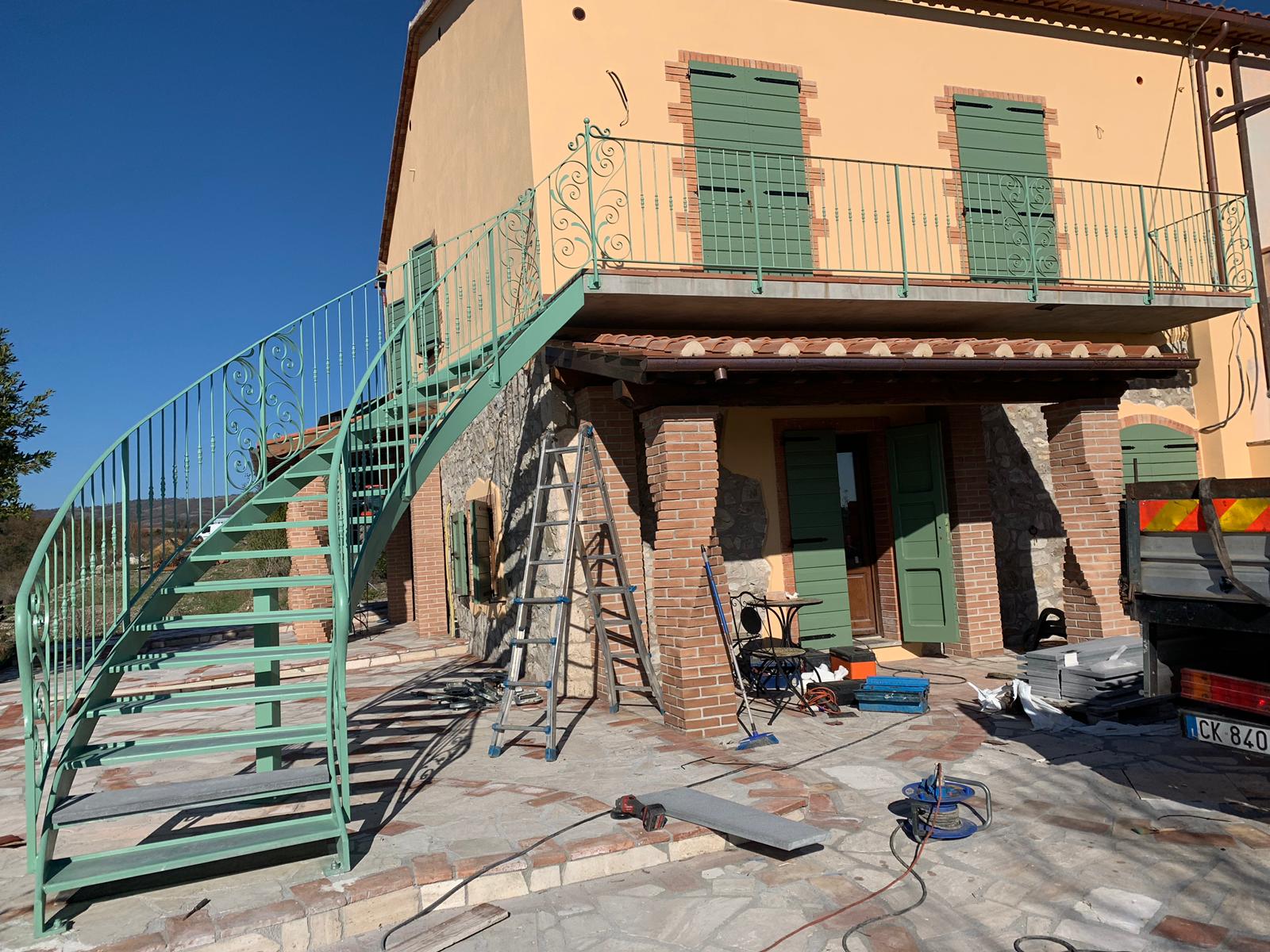 Exterior staircase with decorative green metal railings and scrollwork details